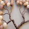 details of tiny branches adorned with wood beads of various sizes and colors
